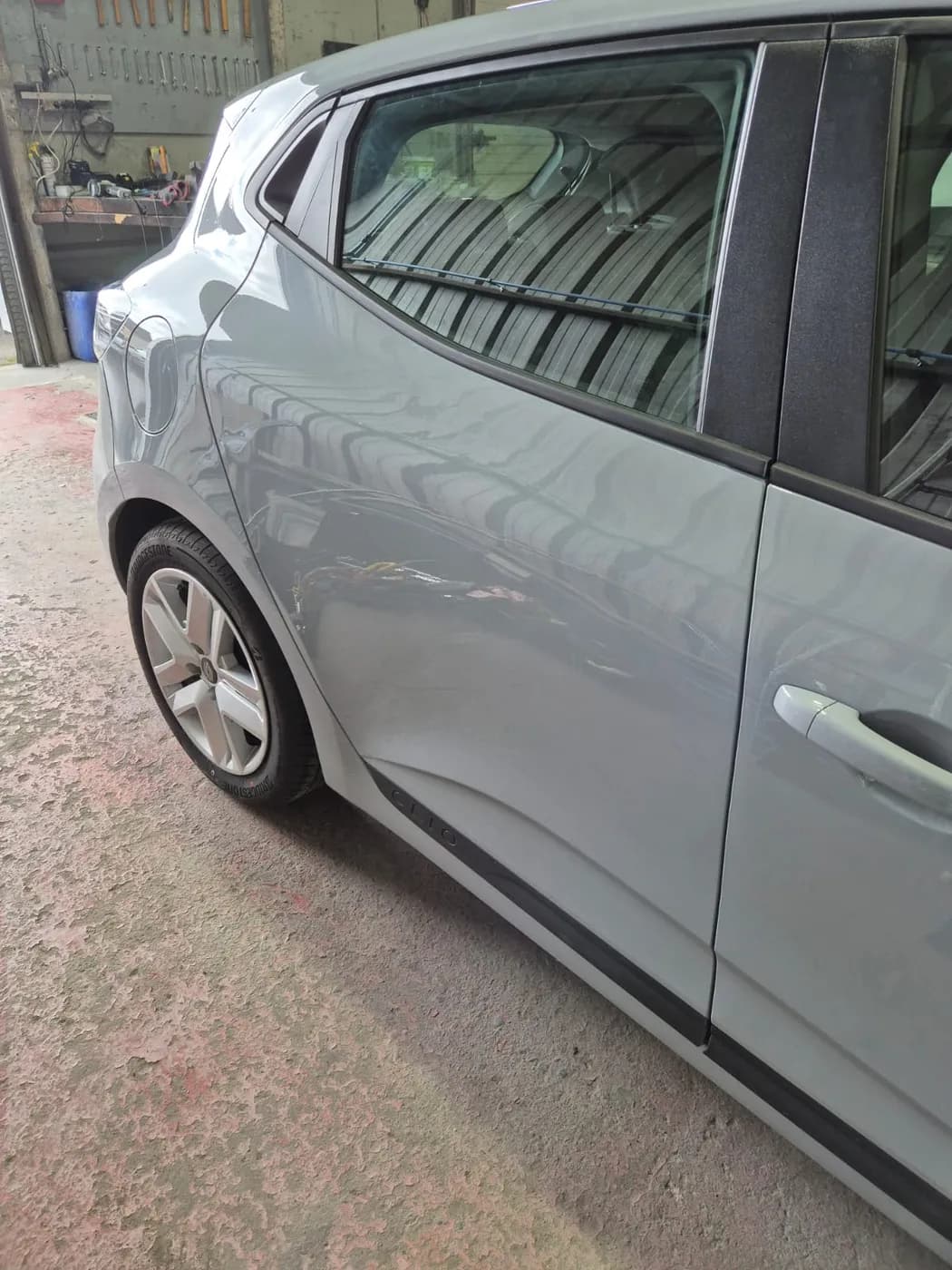 Après — portière arrière fortement enfoncée d'une Renault Clio grise, redressée sans peinture