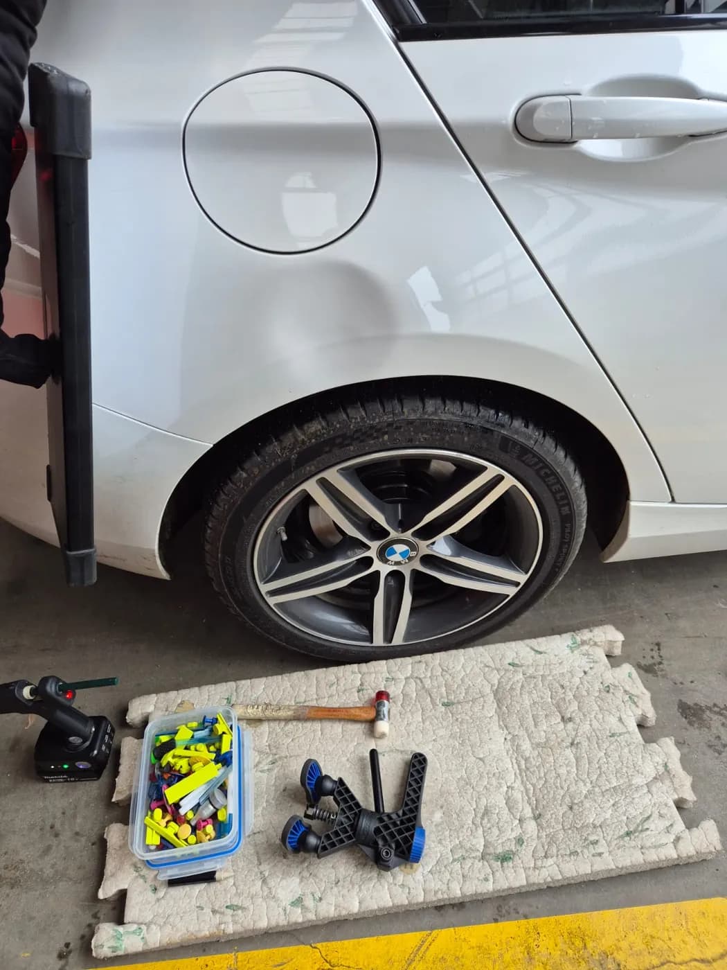 Avant — aile arrière d'une BMW Série 1 blanche, enfoncement redressé sans repeinture