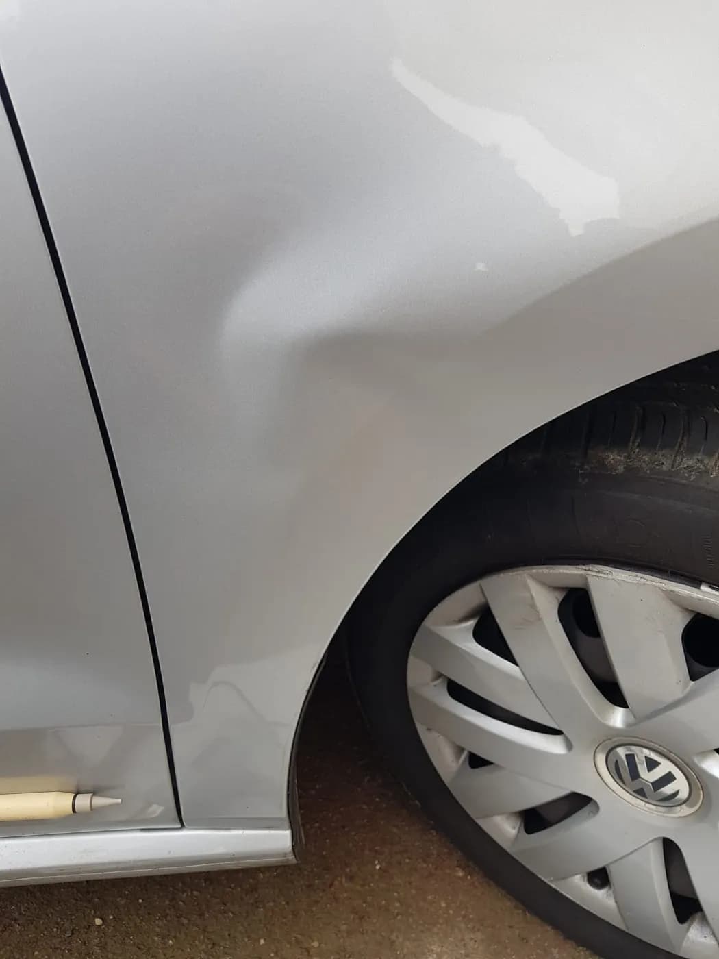 Avant — aile avant d'une Volkswagen grise, coup redressé par débosselage sans peinture